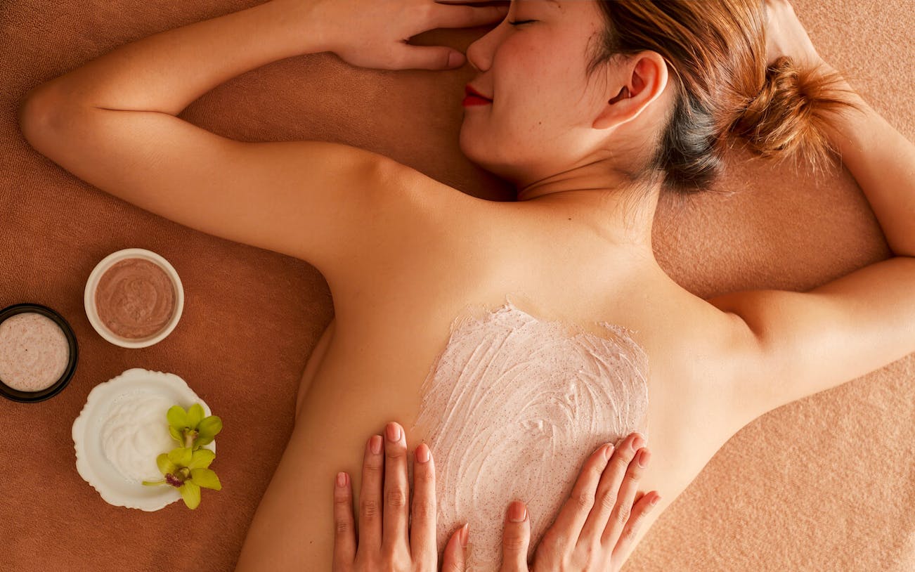 Tourist receiving Diora Signature Body Scrub treatment.