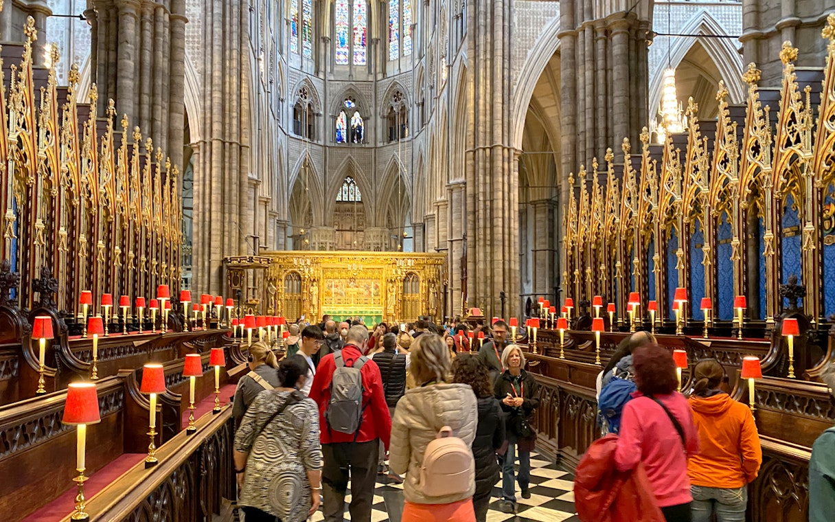 Visitors exploring the ornate interior of Westminster Abbey, London.