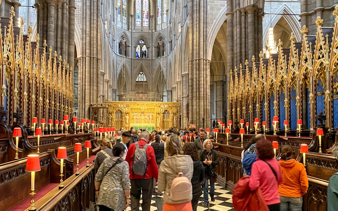 Visitors exploring the ornate interior of Westminster Abbey, London.