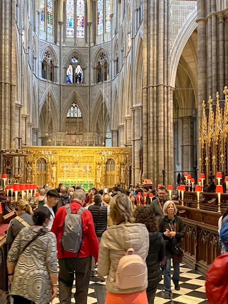 Visitors exploring the ornate interior of Westminster Abbey, London.
