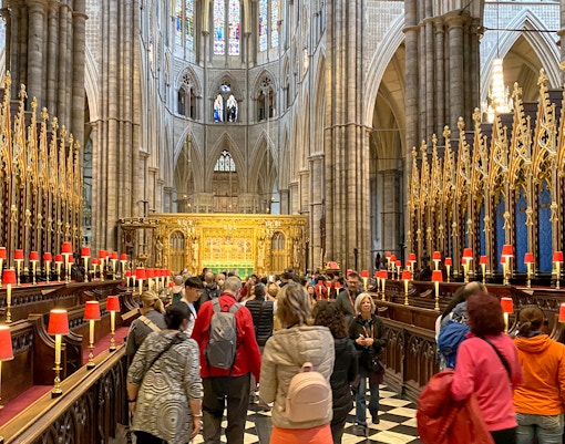 Visitors exploring the ornate interior of Westminster Abbey, London.