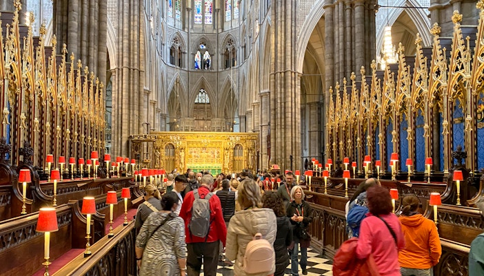 Visitors exploring the ornate interior of Westminster Abbey, London.