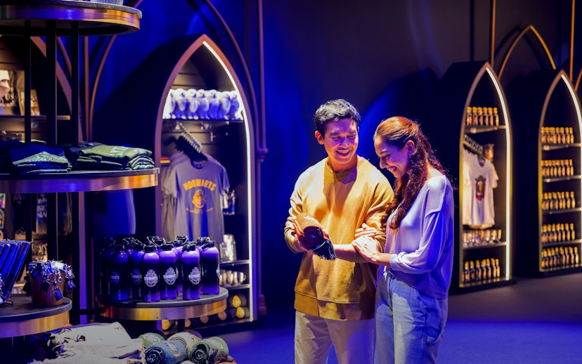 Couple shopping for Harry Potter merchandise at Visions of Magic Ticket Shop.