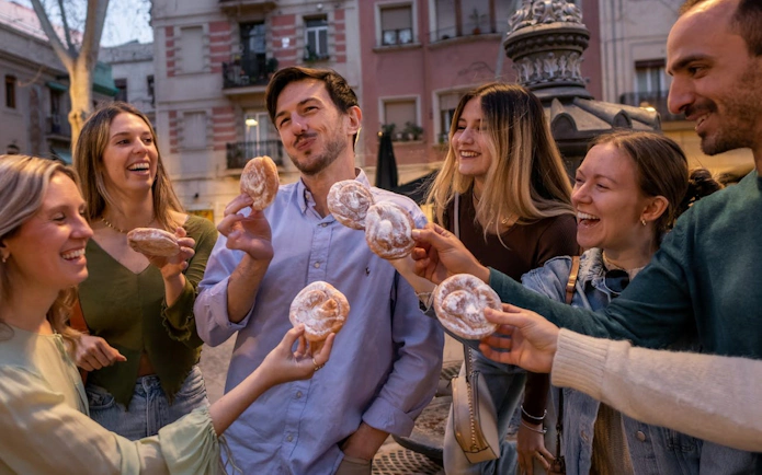 Group enjoying pastries on a Barcelona side street during a tapas and wine tour.
