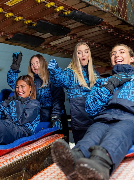 Bobsled ride with people enjoying at Ski Dubai Snow Park.