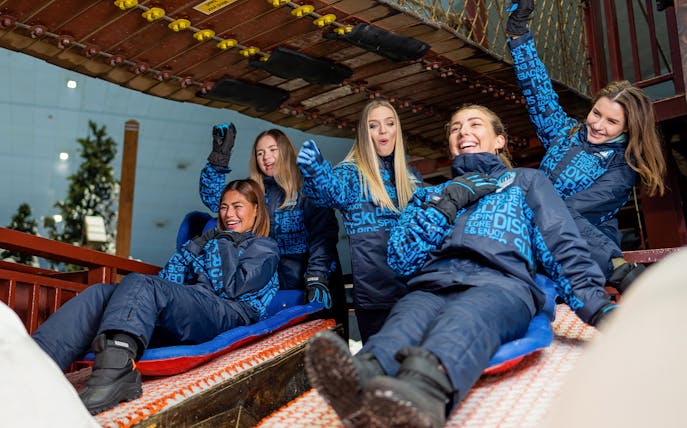 Bobsled ride with people enjoying at Ski Dubai Snow Park.