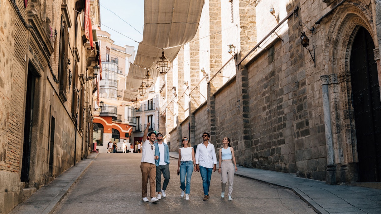 Tourists walking with a guide in Toledo's historic streets.
