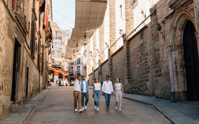 Tourists walking with a guide in Toledo's historic streets.