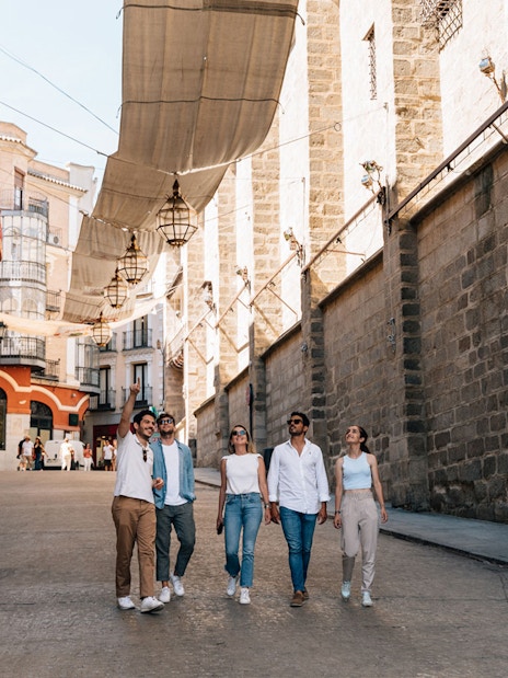 Tourists walking with a guide in Toledo's historic streets.
