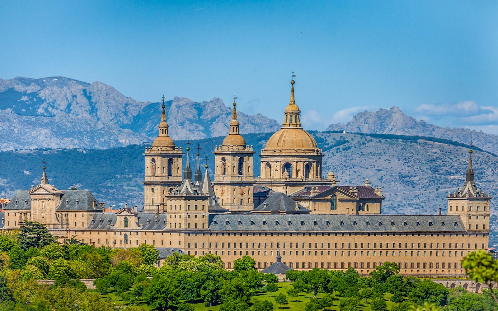 San Lorenzo de El Escorial monastery with mountain backdrop on private tour.