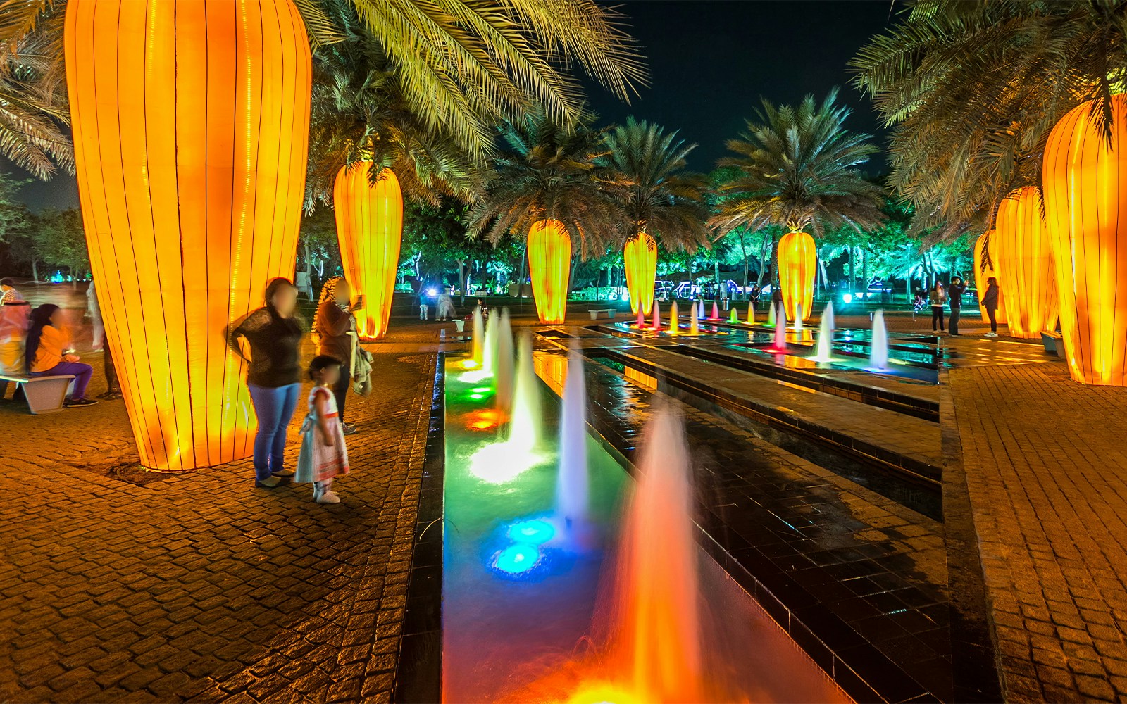 Dubai Garden Glow illuminated pathway with colorful fountains and glowing installations.