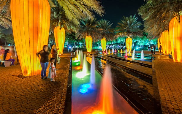 Dubai Garden Glow illuminated pathway with colorful fountains and glowing installations.