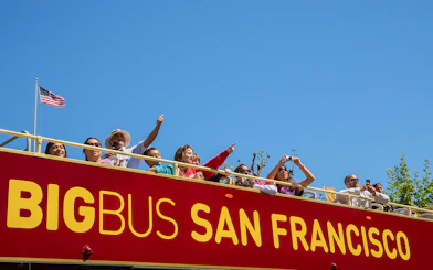 Tourists on a San Francisco hop-on hop-off bus enjoying city views.