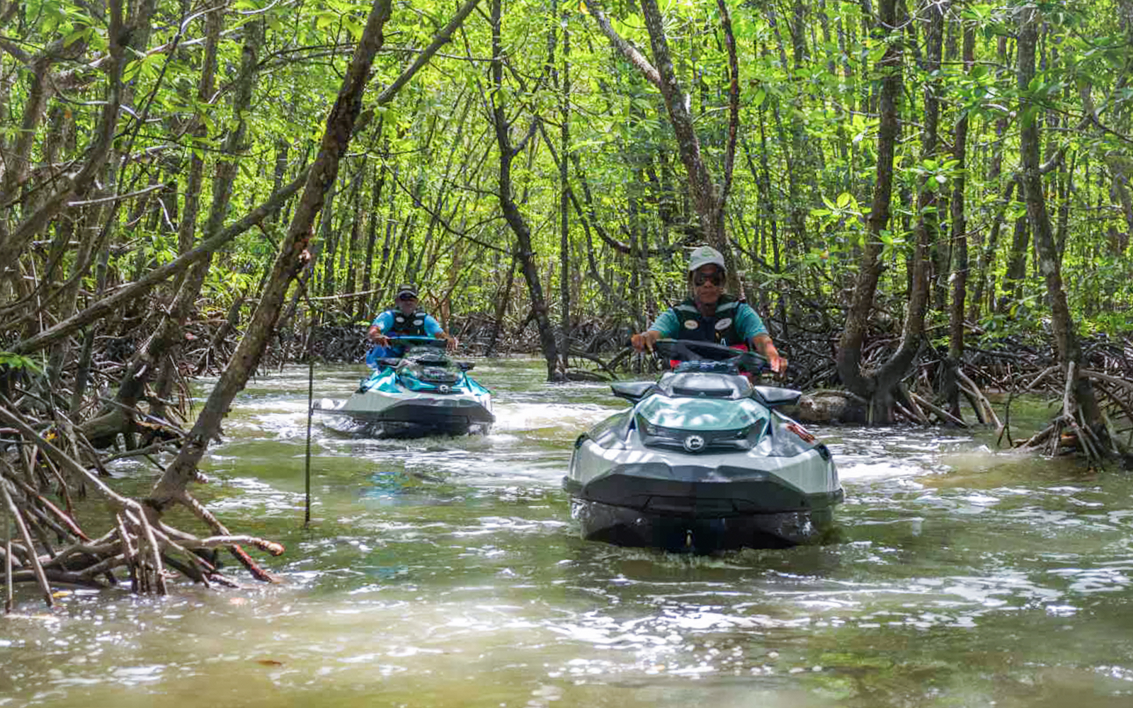 Jet skis navigating mangrove forest in Langkawi's UNESCO Kilim Geopark.