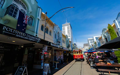 Christchurch street with vintage tram and outdoor cafes on the Ultimate Walking Tour.