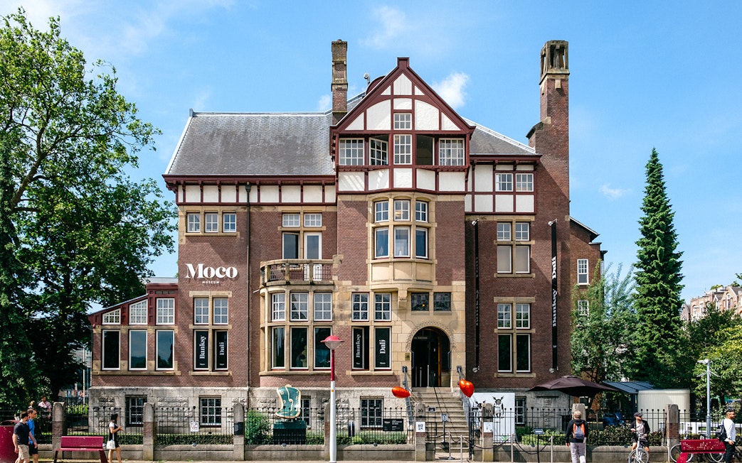 Moco Museum exterior in Amsterdam, showcasing Banksy and Dalí exhibits.