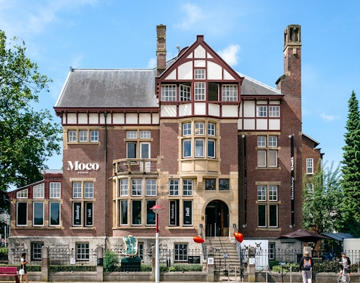 Moco Museum exterior in Amsterdam, showcasing Banksy and Dalí exhibits.