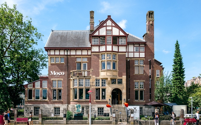 Moco Museum exterior in Amsterdam, showcasing Banksy and Dalí exhibits.