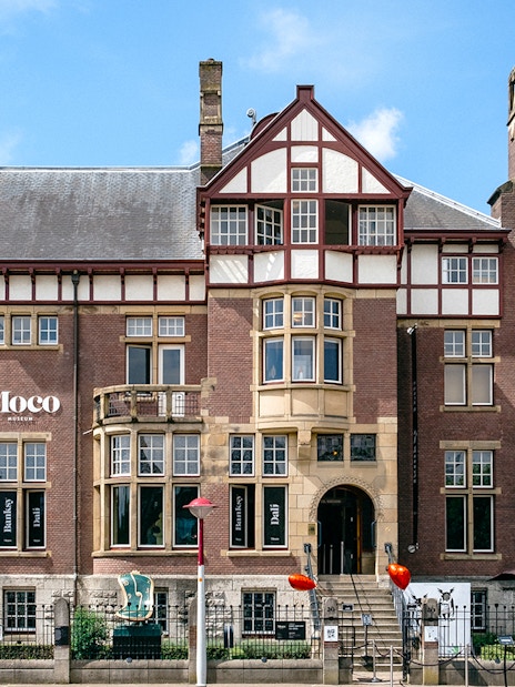 Moco Museum exterior in Amsterdam, showcasing Banksy and Dalí exhibits.