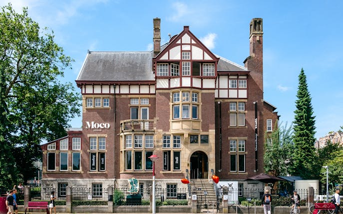 Moco Museum exterior in Amsterdam, showcasing Banksy and Dalí exhibits.