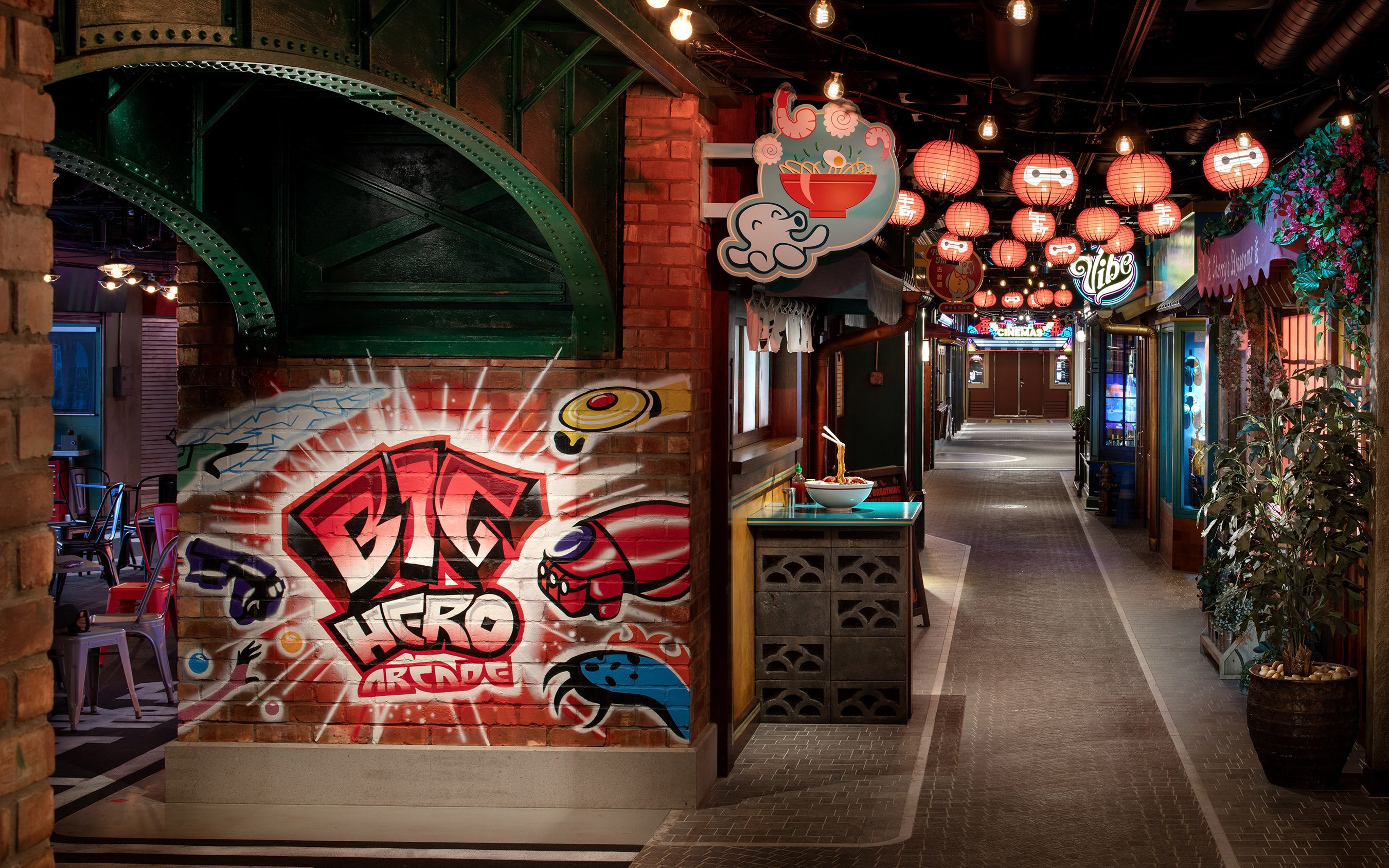 San Fransokyo street scene on Disney Cruise Line with Big Hero arcade mural and lanterns.