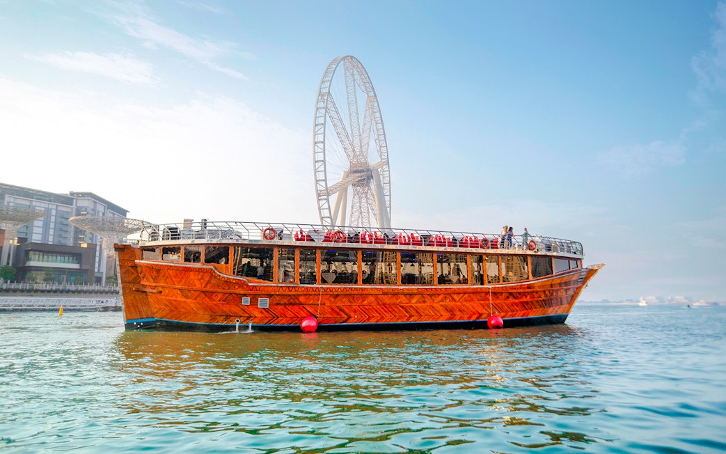 Dhow cruise on Dubai Creek with Ain Dubai in the background.