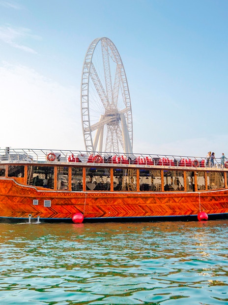 Dhow cruise on Dubai Creek with Ain Dubai in the background.