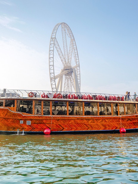 Dhow cruise on Dubai Creek with Ain Dubai in the background.