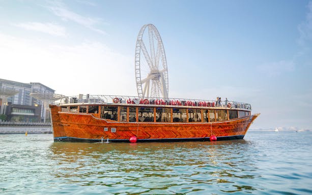 Dhow cruise on Dubai Creek with Ain Dubai in the background.