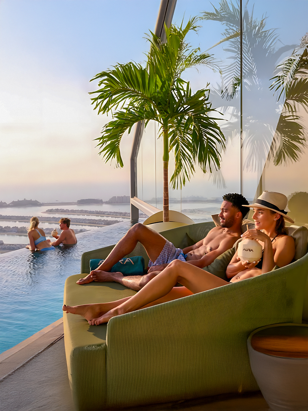 Couples relaxing at AURA Sky Pool, Dubai, with sunrise view over the city.