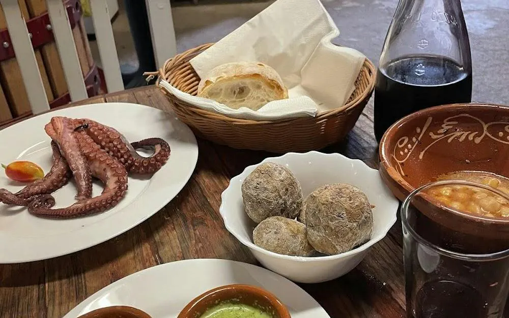 Canarian tapas with octopus, wrinkled potatoes, and wine on Tenerife tour.
