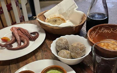 Canarian tapas with octopus, wrinkled potatoes, and wine on Tenerife tour.