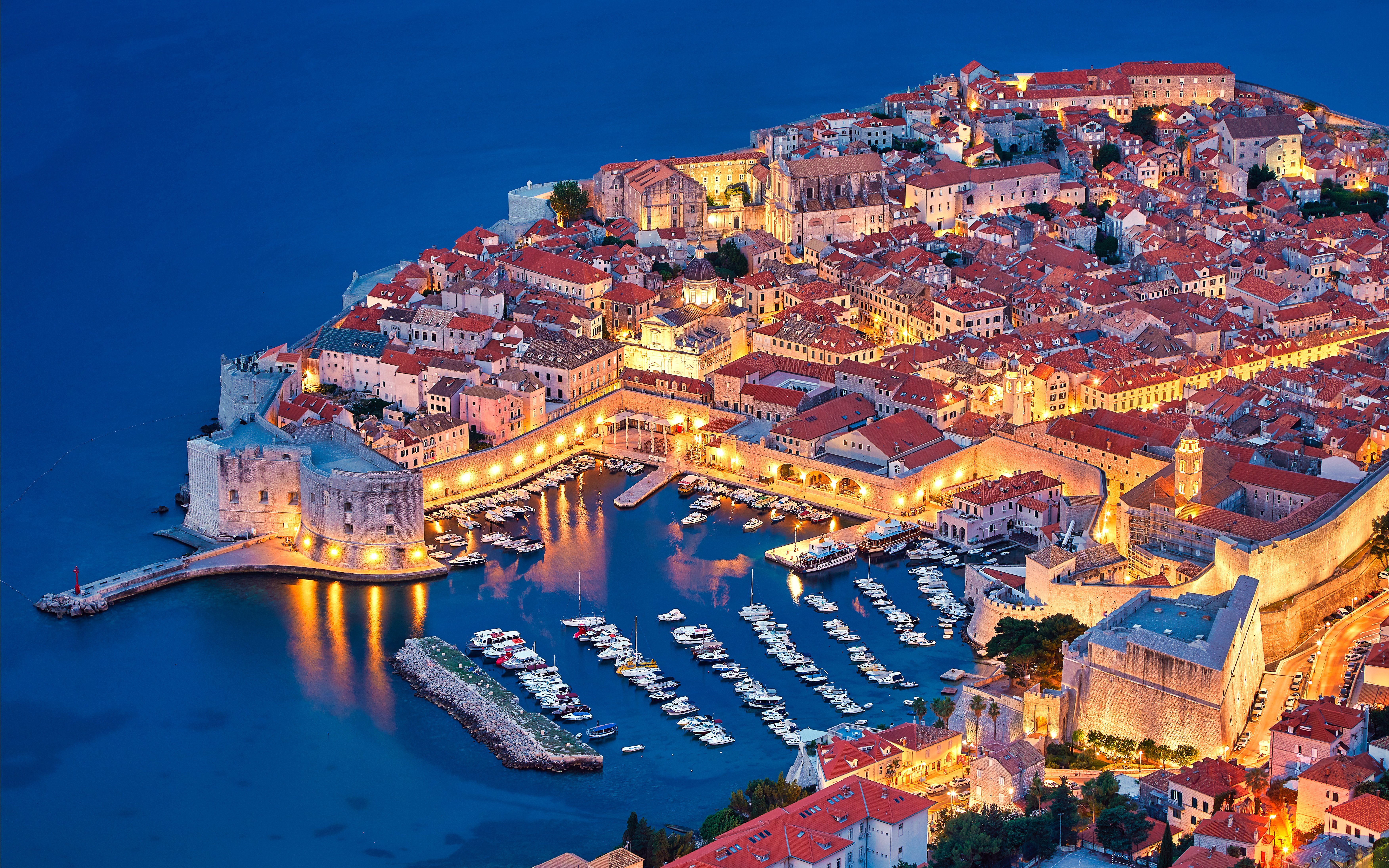 Aerial view of Dubrovnik's illuminated Old Town and harbor at night, Croatia.