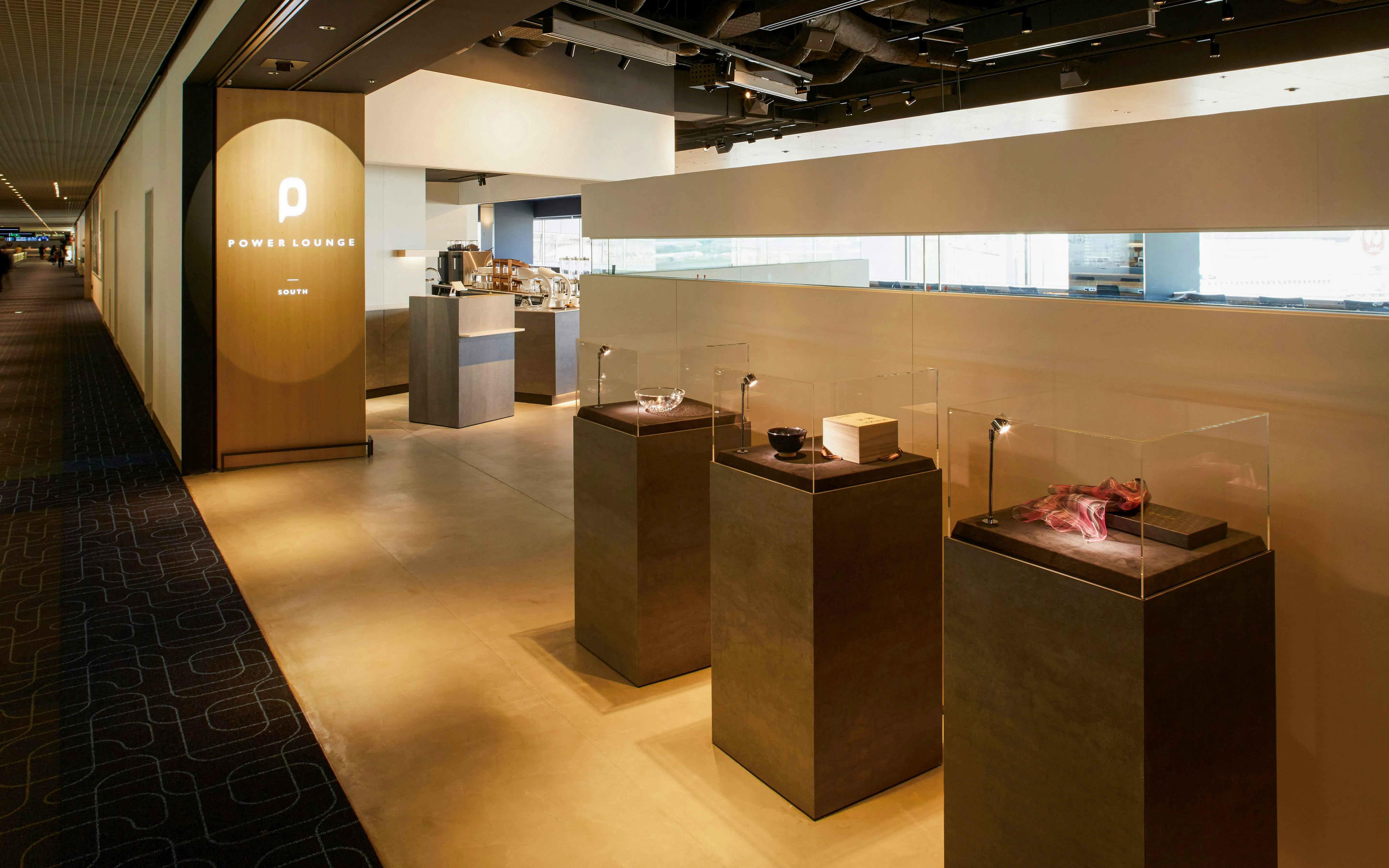 Power Lounge South entrance at Tokyo International Airport with display cases.