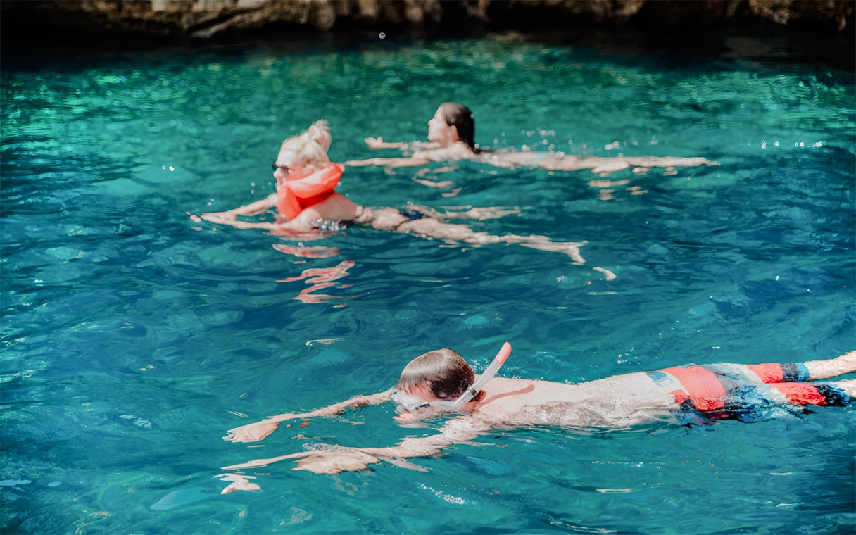 Snorkelers exploring clear waters on Blue Cave and Blue Lagoon tour.