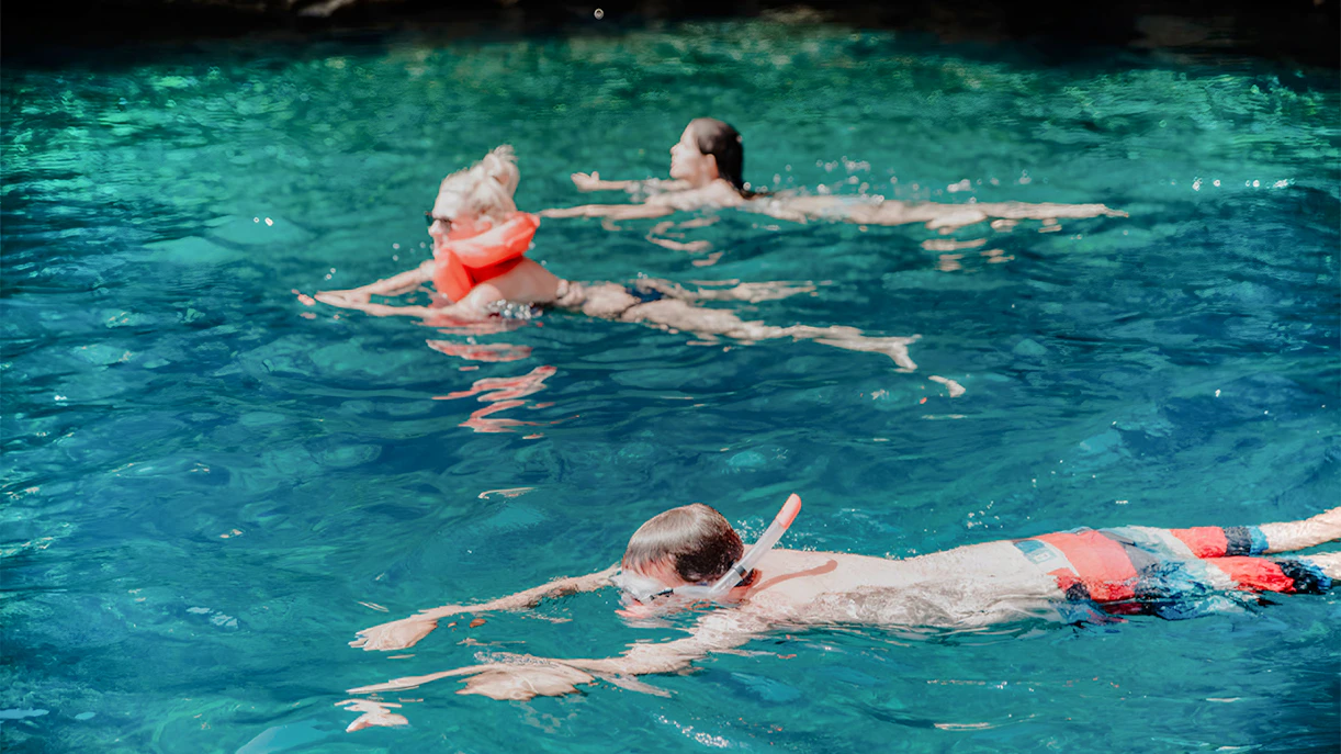 Snorkelers exploring clear waters on Blue Cave and Blue Lagoon tour.