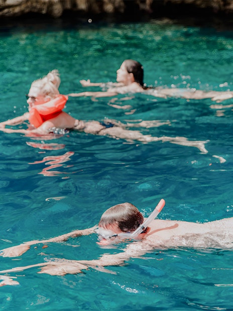 Snorkelers exploring clear waters on Blue Cave and Blue Lagoon tour.