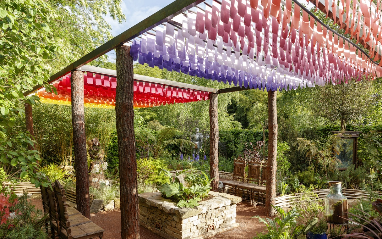 Colorful canopy and garden at Chaumont-sur-Loire Castle, featuring lush greenery and a stone planter.