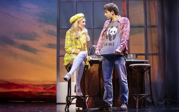 Two actors on stage in Clueless The Musical, one in a yellow plaid outfit, the other in a panda shirt.