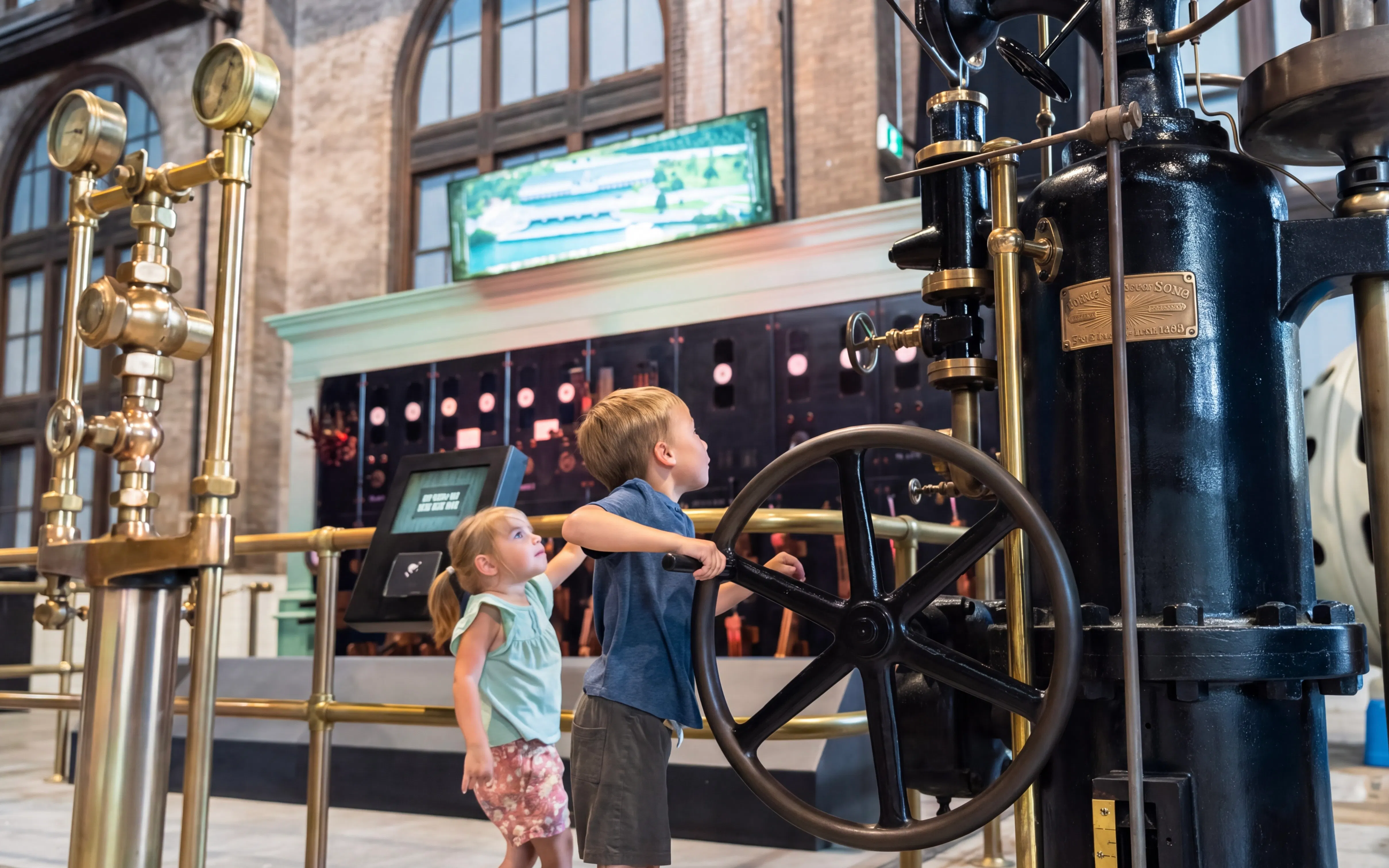 Children exploring machinery at Niagara Parks Power Station during the day.