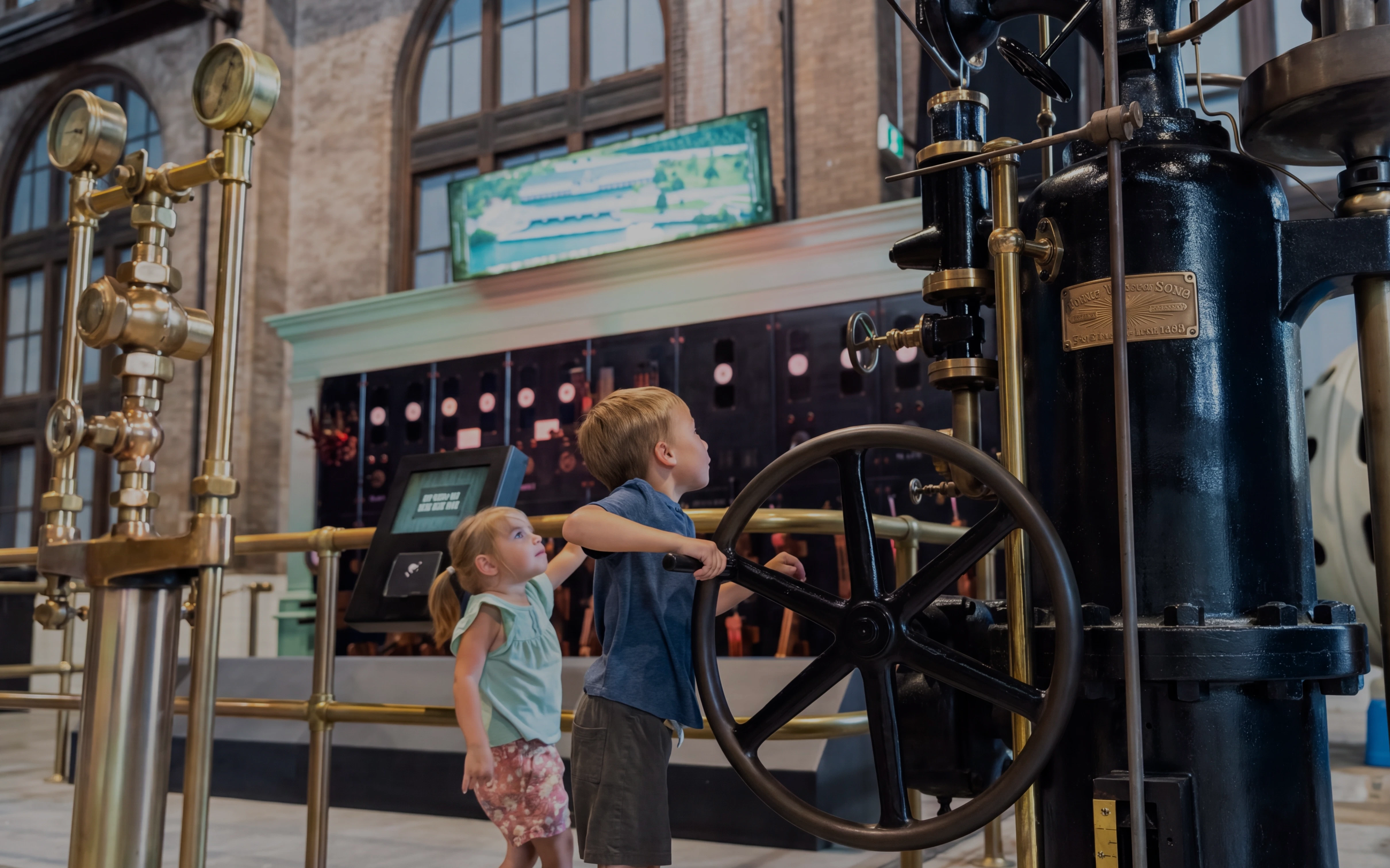 Children exploring machinery at Niagara Parks Power Station during the day.