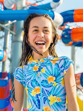 Child enjoying water park slides at Gold Coast during school holiday special.
