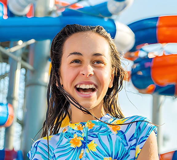 Child enjoying water park slides at Gold Coast during school holiday special.