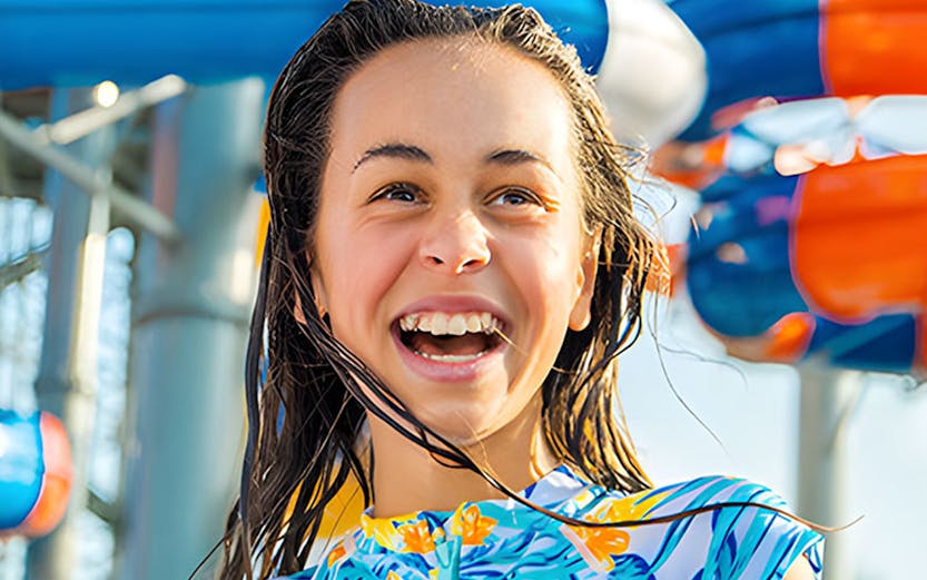 Child enjoying water park slides at Gold Coast during school holiday special.