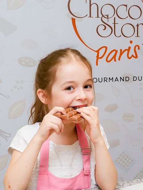 Child enjoying chocolate tasting at Choco-Story Museum, Paris.