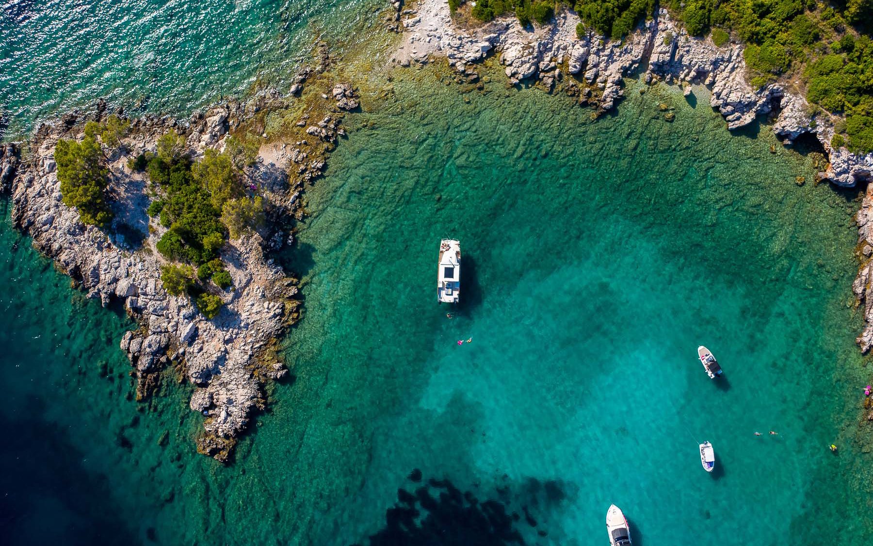 Aerial view of boats near rocky coastline of Koločep, Croatia.