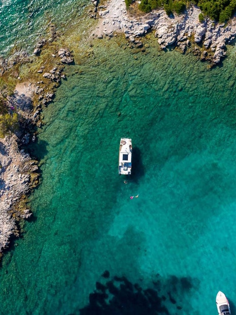 Aerial view of boats near rocky coastline of Koločep, Croatia.