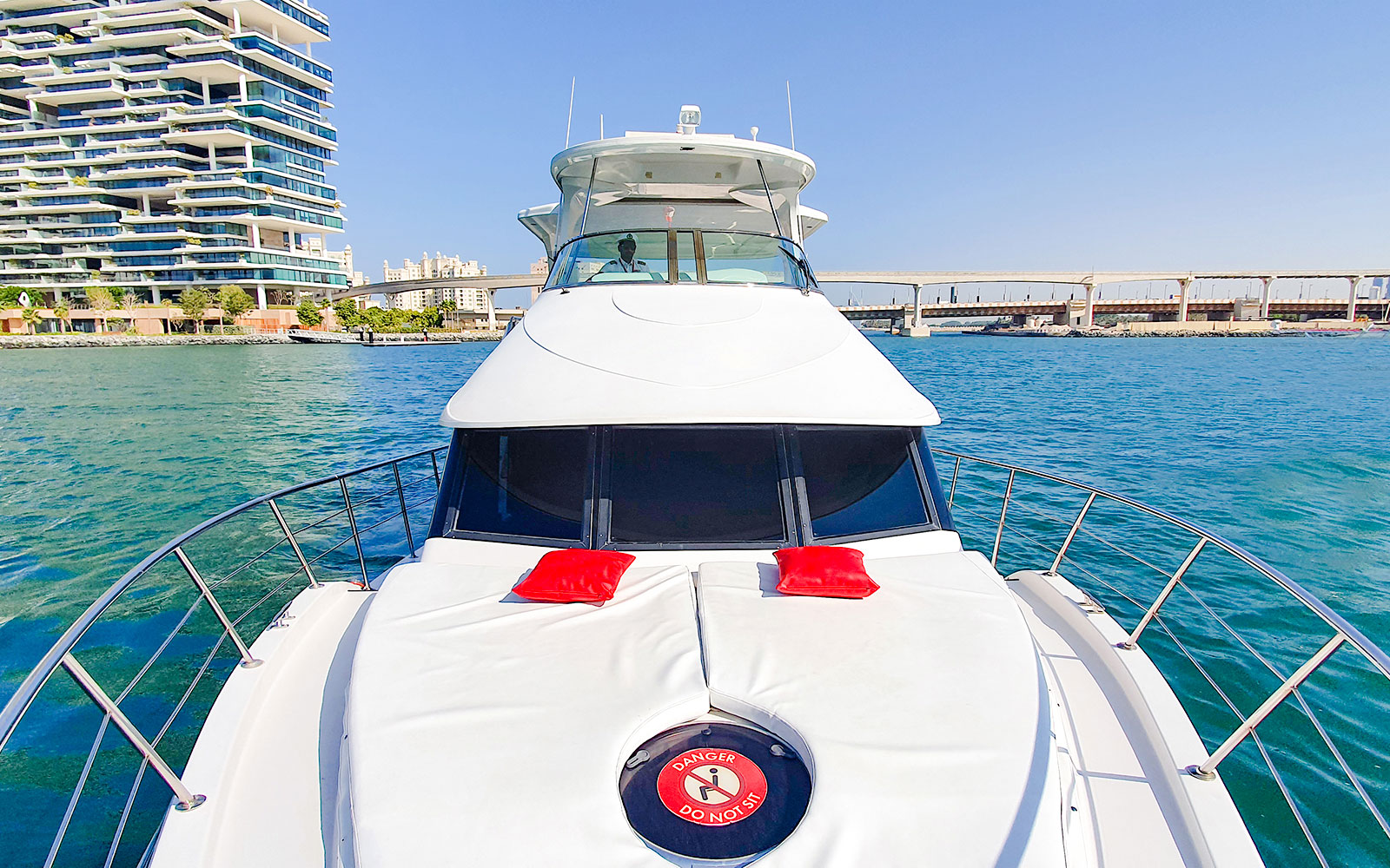 Luxury yacht cruising near Dubai Marina with modern buildings in the background.