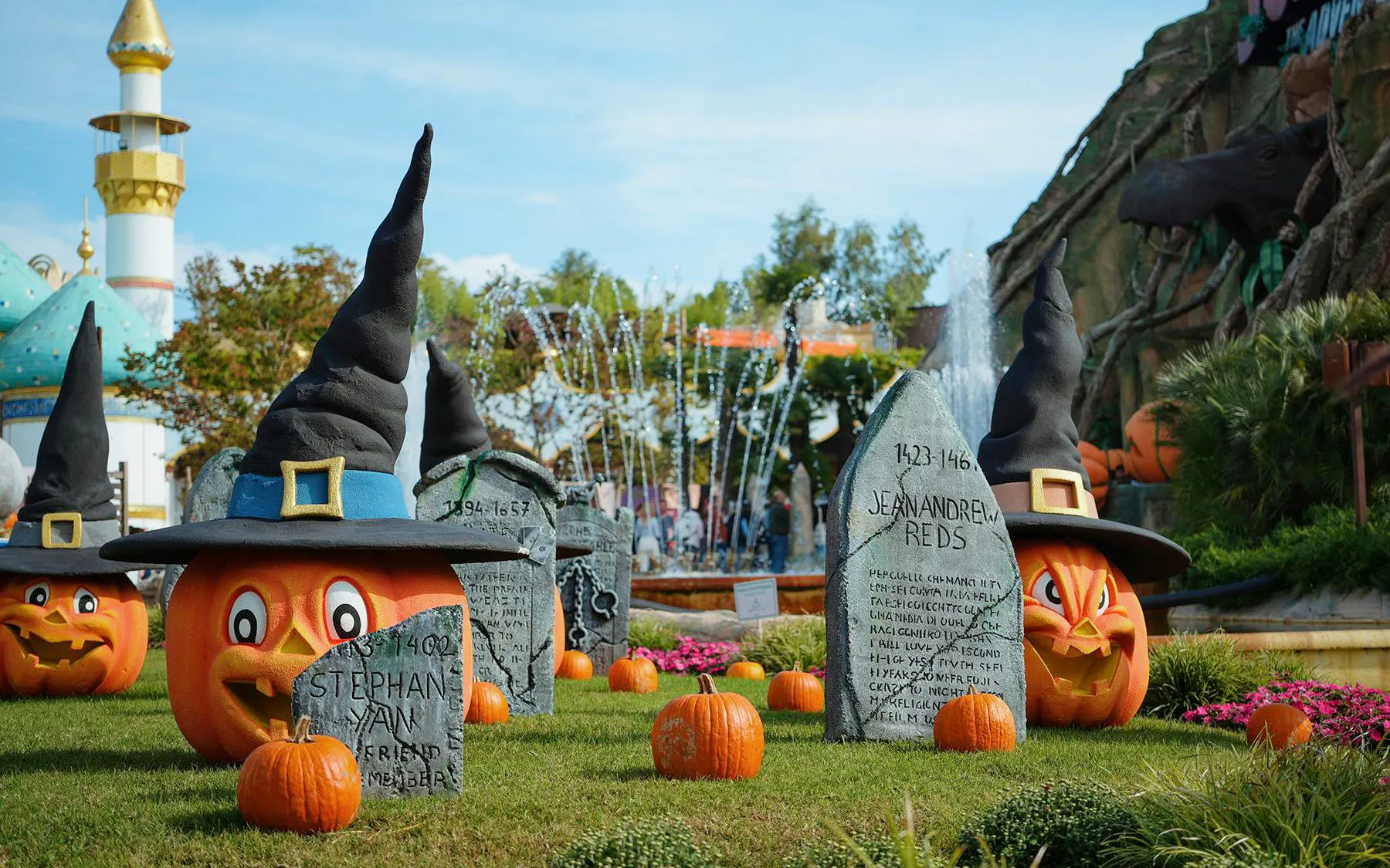 Gardaland Halloween display with pumpkins wearing witch hats and tombstones.