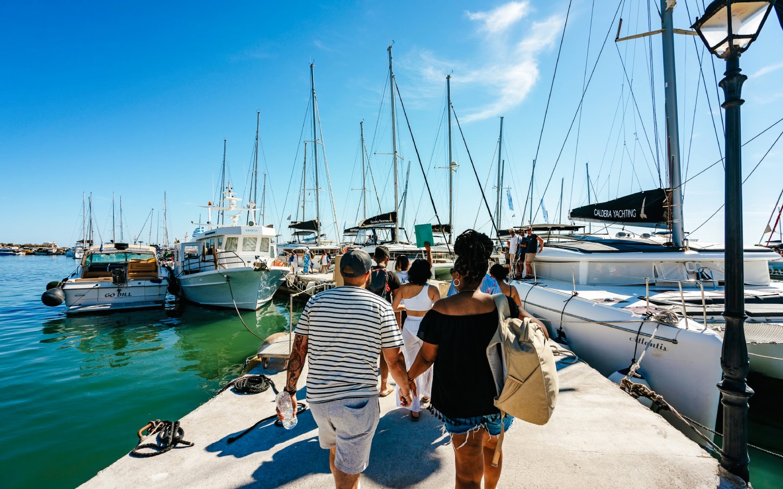 Guests boarding a catamaran for a classic cruise at a marina.